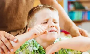 Chłopiec z ADHD, zaciśnięta pięść, zmartwiona mina. Jak postępować, by mu pomóc?
