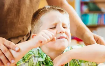 Chłopiec z ADHD, zaciśnięta pięść, zmartwiona mina. Jak postępować, by mu pomóc?