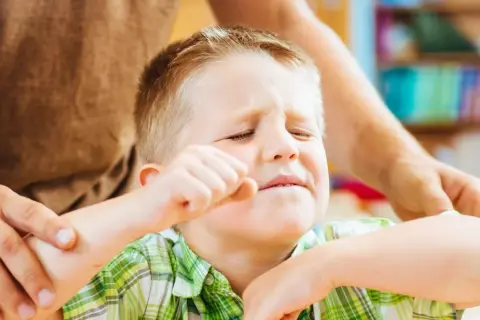 Chłopiec z ADHD, zaciśnięta pięść, zmartwiona mina. Jak postępować, by mu pomóc?